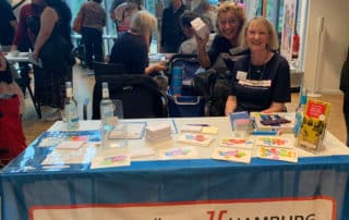 Sprachbrücke-Hamburg e.V. war mit einem Stand auf der „Integrationsmesse Bergedorf“ vertreten. Auf dem Bild sind zwei gut gestimmte Frauen zu sehen.