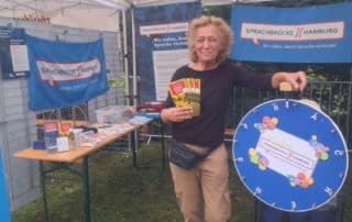 Vereinsvorsitzende Annja Haehling von Lanzenauer präsentiert Sprachbrücke-Hamburg e.V. und das Projekt „Sprache im Alltag“ bei „Harburg feiert Vielfalt“. Neben ihr das Sprachbrücken-Glücksrad.