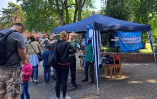 Sprachbrücke-Hamburg e.V. beim Fest zum Weltkindertag in Eidelstedt. Auf dem Foto: Der Vereinsstand, davor mehrere interessierte Besuchende.