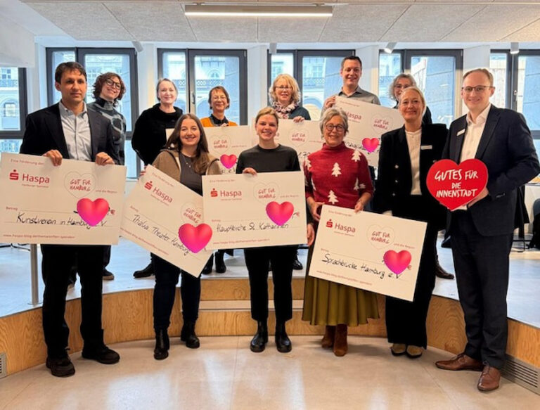Stolz präsentieren Mitarbeiter der Haspa Schecks für gemeinnützige Vereine