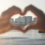 Herzförmige Hand mit Blick auf die Skyline von Hamburg