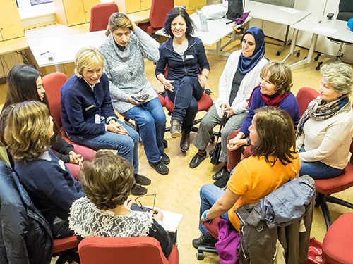 Mehrere Personen sitzen bei einer Gesprächsrunde von Sprachbrücke-Hamburg e.V. in einer Sitzgruppe